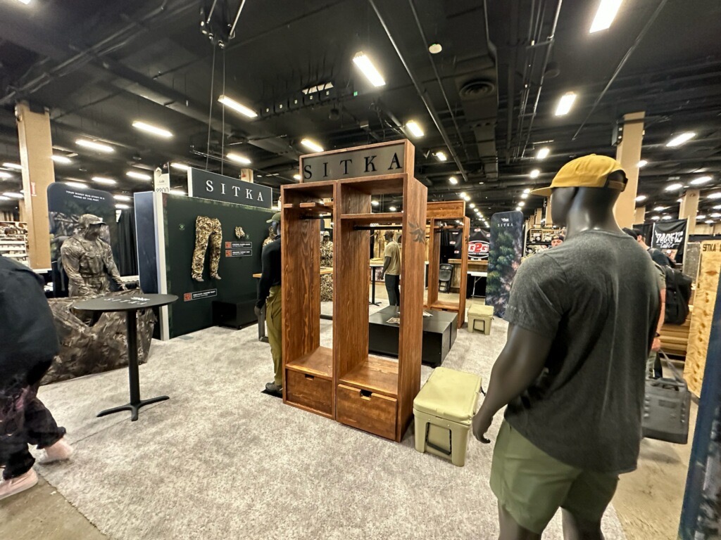 dark wood stained lockers with drawers and racks labeled "SITKA" and with company logo and products, being featured at a trade show in Nashville, TN